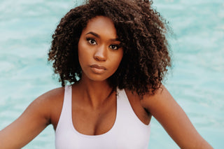Black woman with healthy natural curls and layers in soft natural light — Rucker Roots Summer Hair Survival Guide